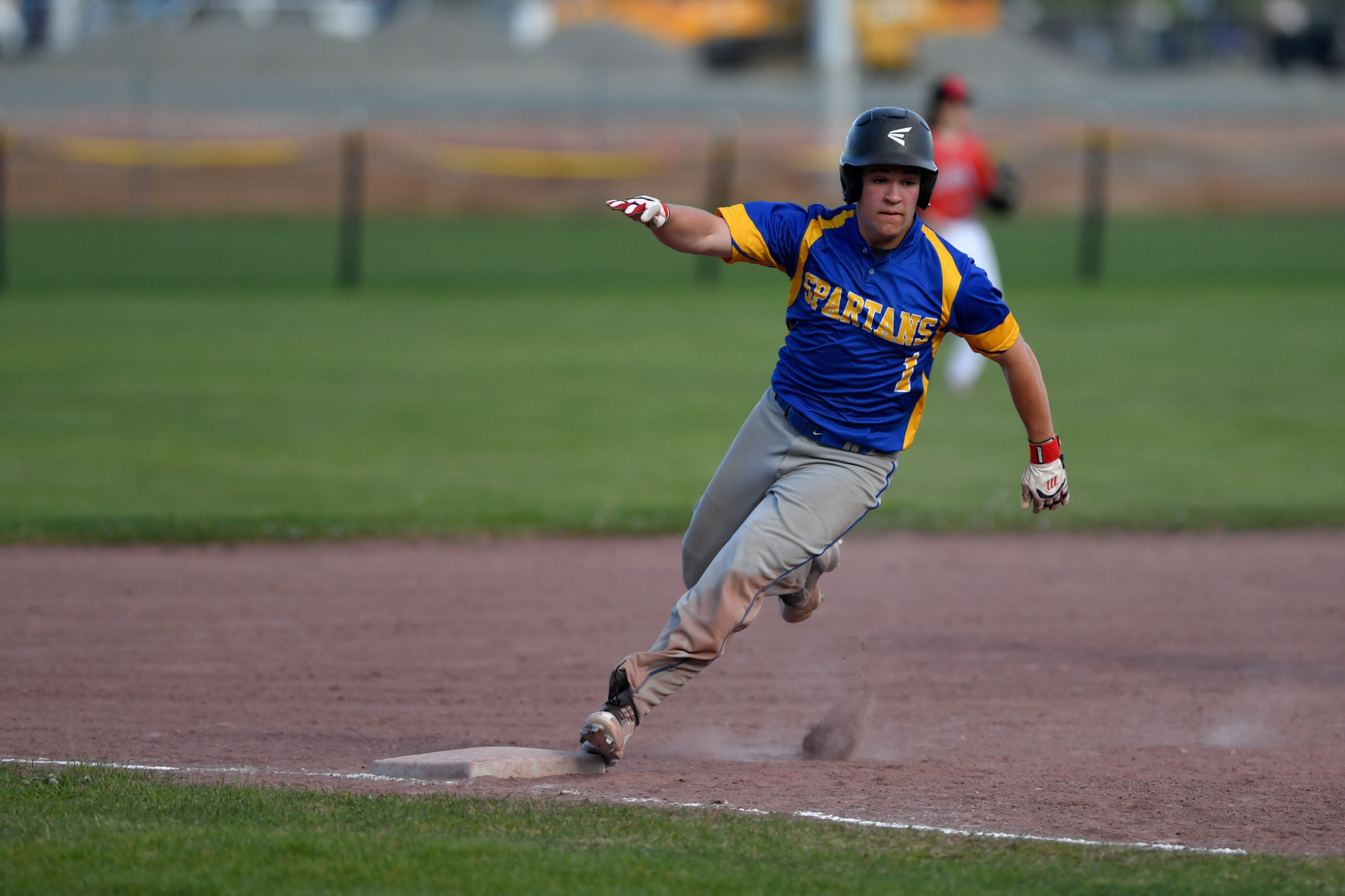 Carson Correa (1) of Queensbury rounds third and heads home to score